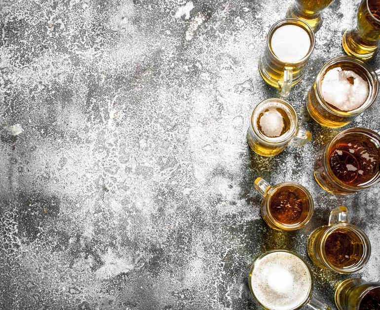 Assorted beer glasses featuring different styles such as lager, IPA, stout, and wheat beer, arranged to highlight variety in flavor and appearance.