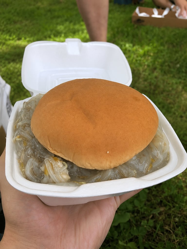 Chop Suey Sandwich in to-go tray being held outdoors.