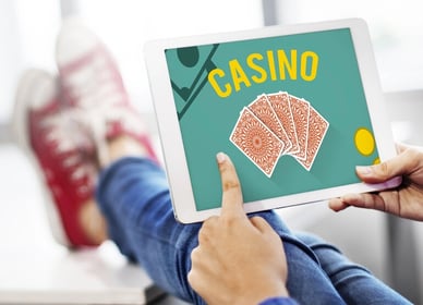 Person using a tablet with an online casino game, highlighting the need to read terms and conditions before signing up in New Zealand.