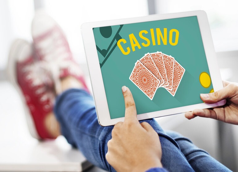 Person using a tablet with an online casino game, highlighting the need to read terms and conditions before signing up in New Zealand.