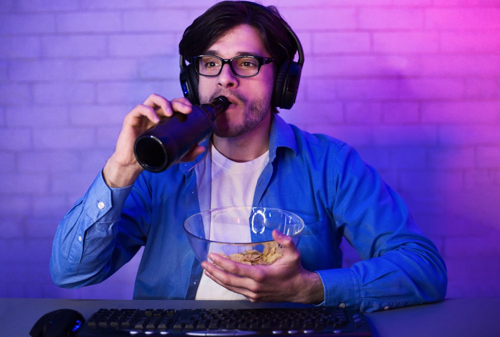 Man playing a perya game on a computer while enjoying beer.