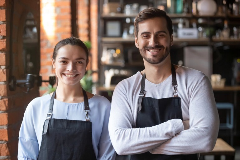Best chef aprons for restaurant staff wearing black aprons in a professional kitchen.