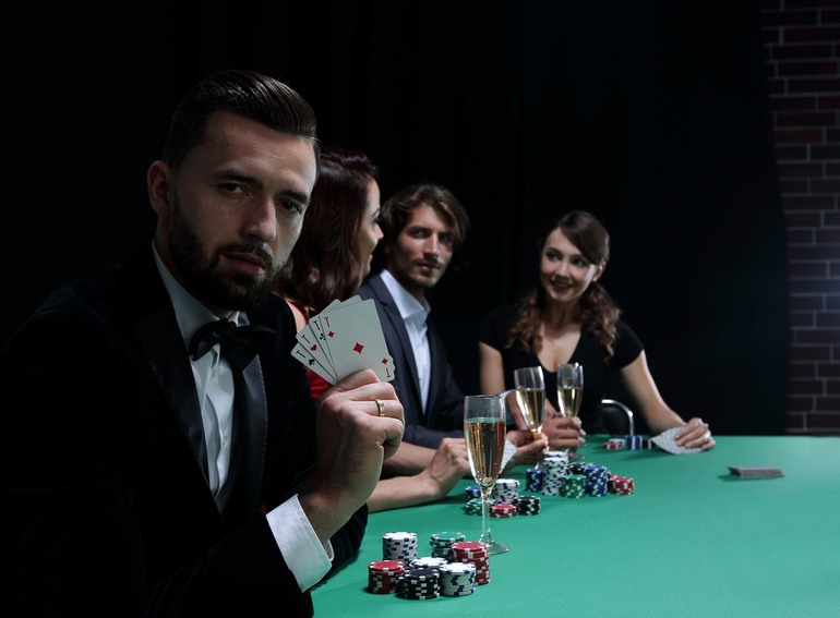 People playing poker at a casino table while enjoying beer during a casino night.