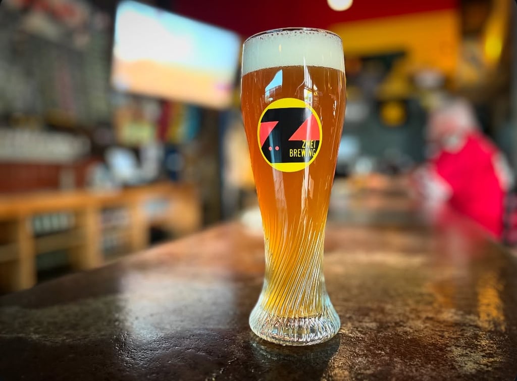Zwei Brewing beer in branded glassware on bartop.