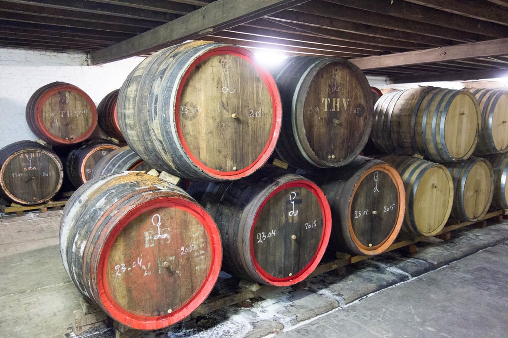 Hanssens Artisanaal cellar, holding multiple barrels of aging kriek and gueuze.