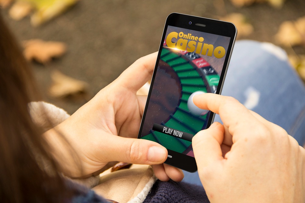A woman playing an online casino game on a phone.