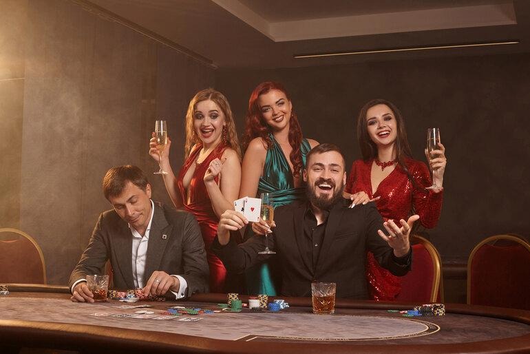 Friends enjoying craft beer and casino entertainment at a lively gaming table.
