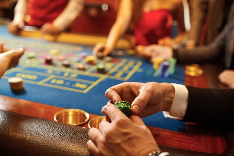 People sitting together at home playing social casino games with chips while enjoying beer during a relaxed evening.