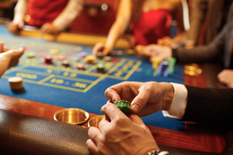 People sitting together at home playing social casino games with chips while enjoying beer during a relaxed evening.