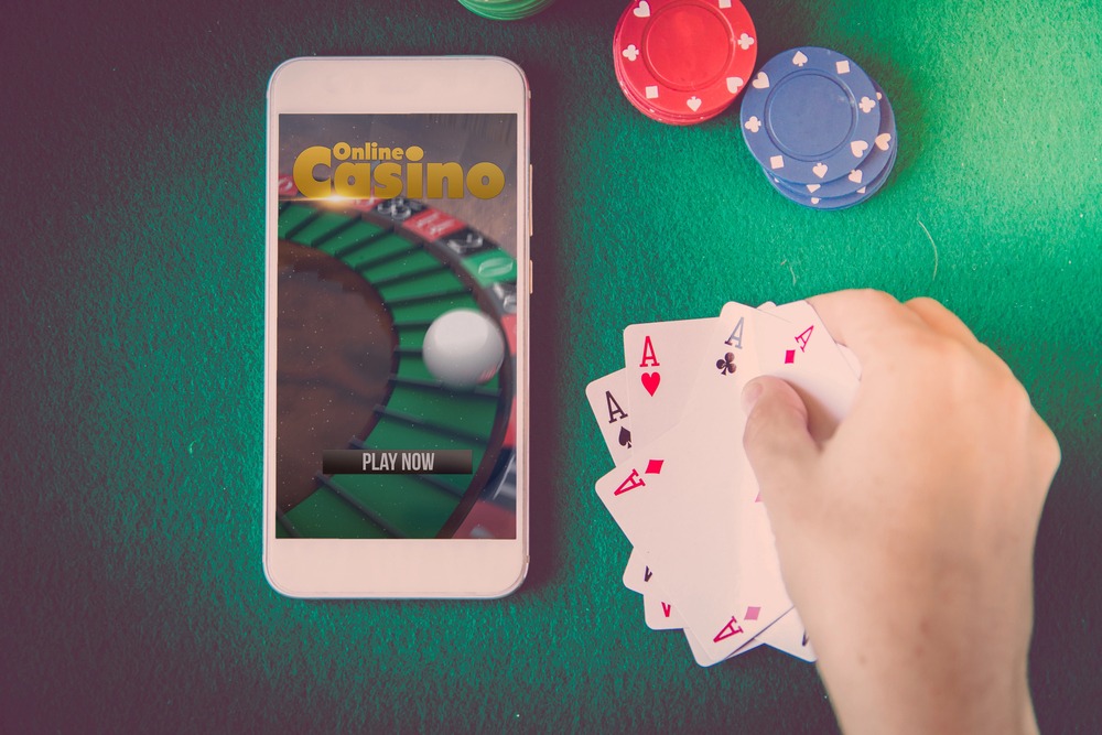A Smartphone with an online casino website on screen, chips and cards.