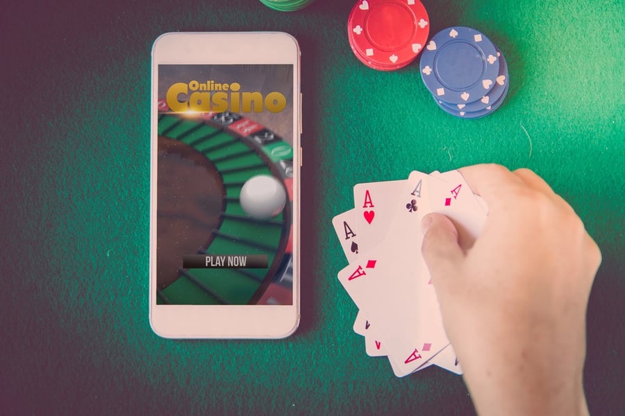 A Smartphone with an online casino website on screen, chips and cards.