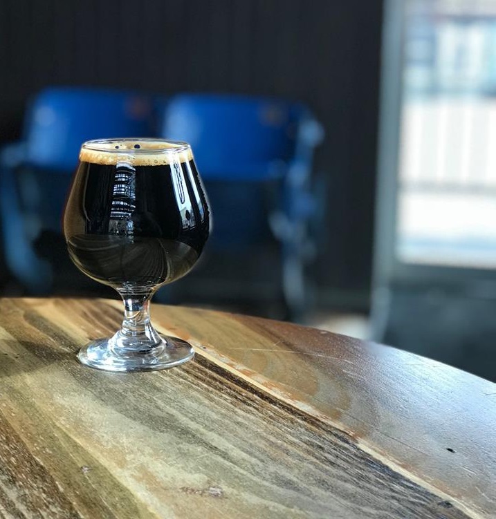 dark beer sitting in a glass on a table