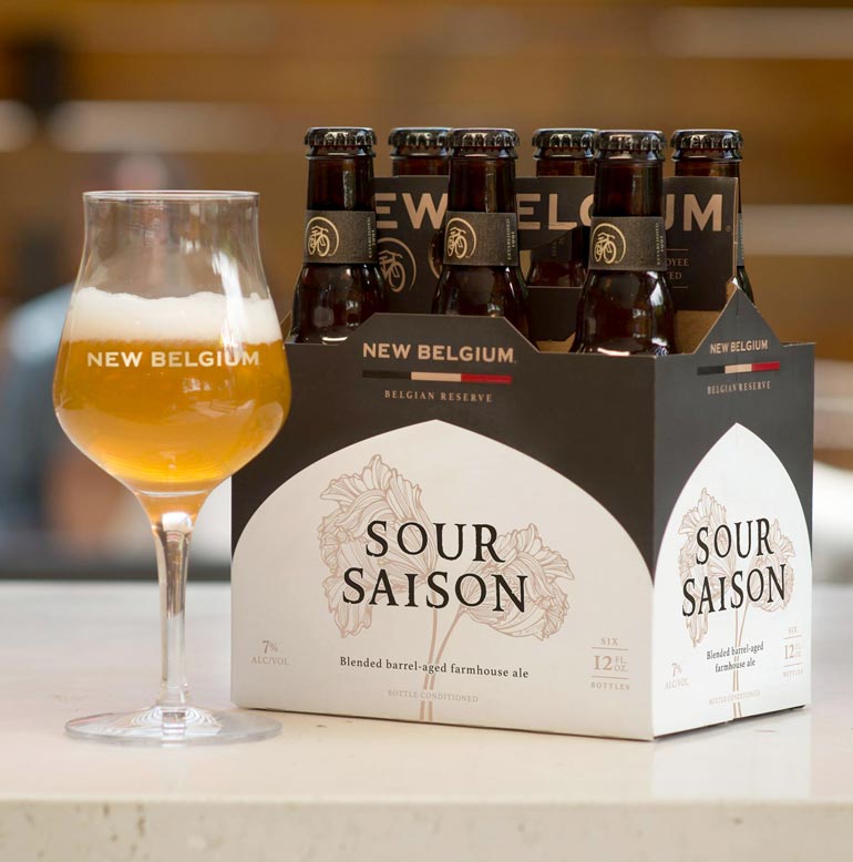 new belgium sour saison six-pack and glassware on tabletop
