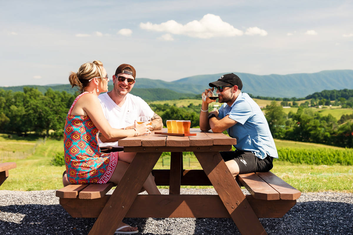 three drinkers enjoying beer outside in the shadow of the appalachian mountains