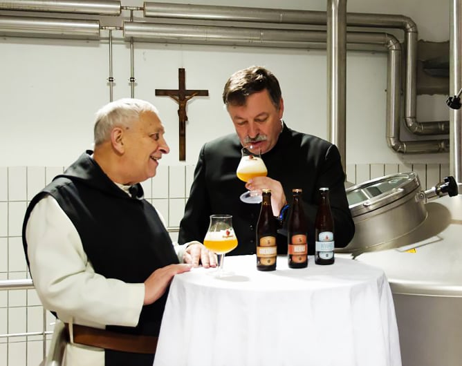 monks sampling trappist ale in front of crucifix