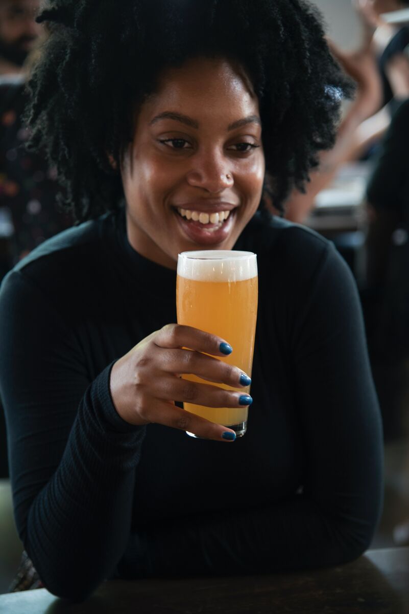 woman smiling and drinking a beer