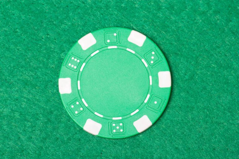 Green poker chip on a green table