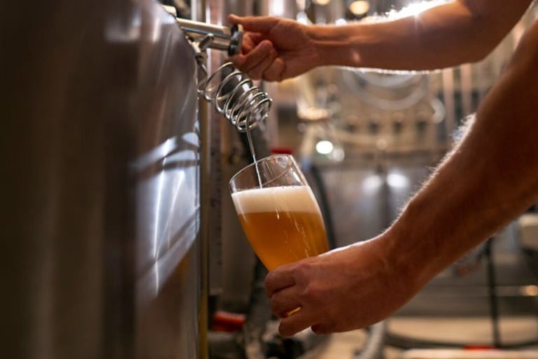 A person pouring a glass of beer