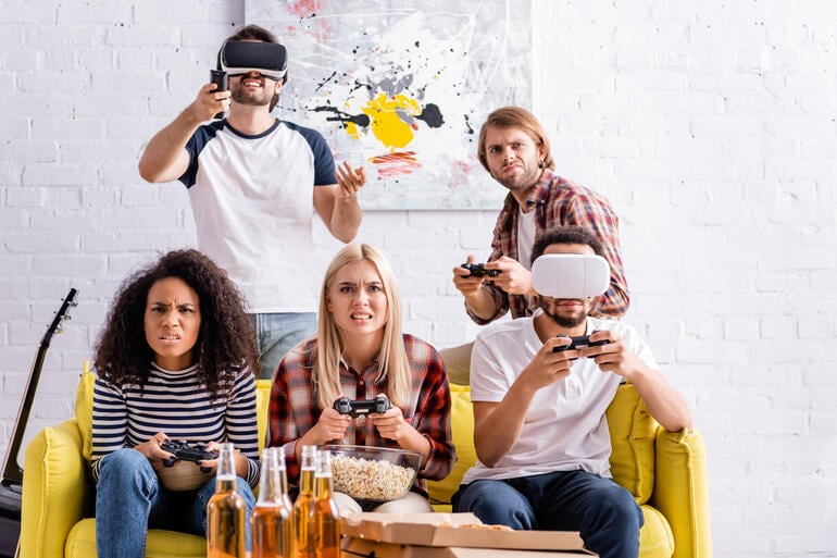 Friends enjoying a fun virtual game night with VR headsets and beer bottles