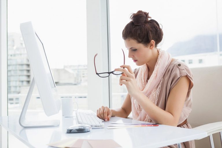 A woman with glasses reviews a document related to RFP management