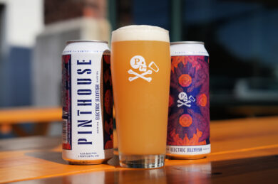 Cans of Electric Jellyfish next to a glass full of the Austin IPA.