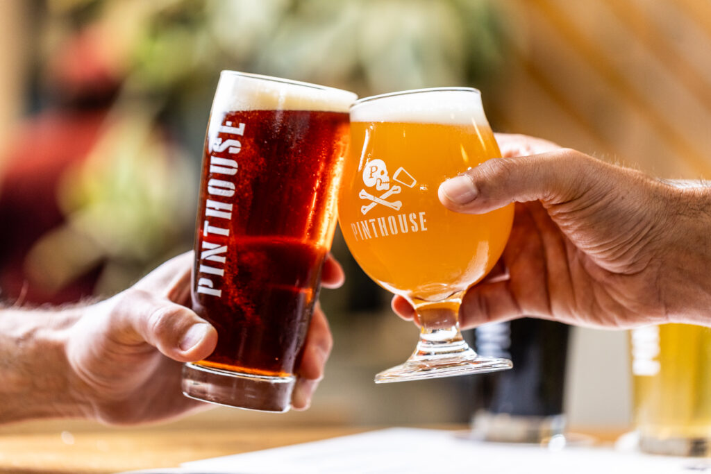 Two Pinthouse Brewing beers, including Electric Jellyfish, being cheersed at the brewery.