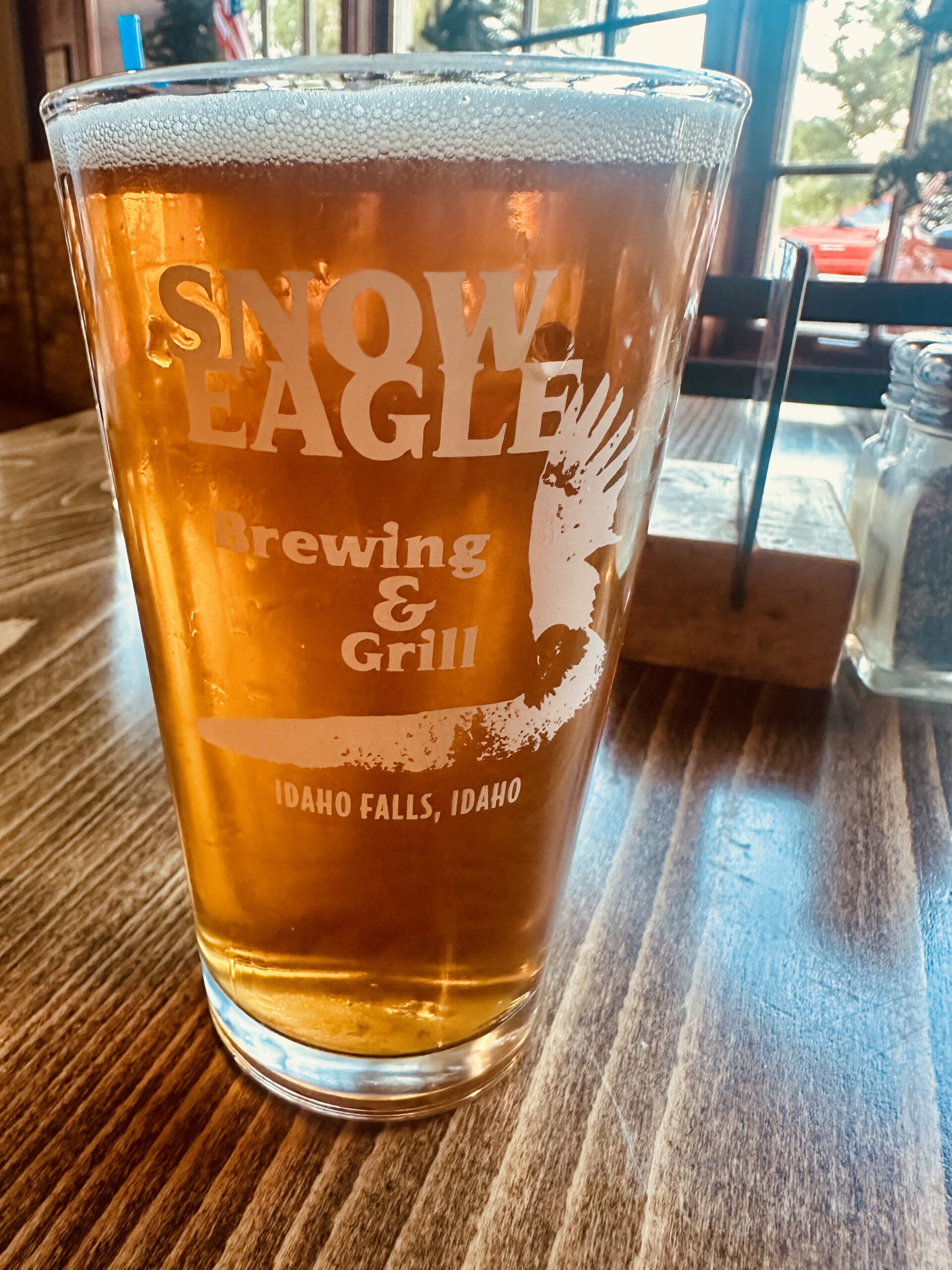 Snow Eagle Brewing & Grill branded glassware on tabletop