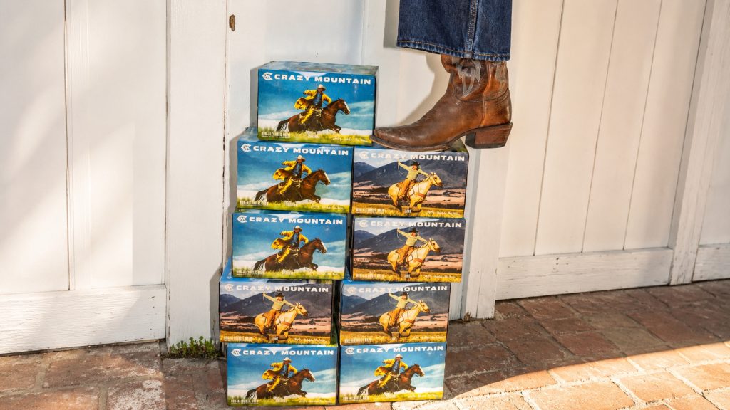 packs of Crazy Mountain non alcoholic beer, with a boot on top of them